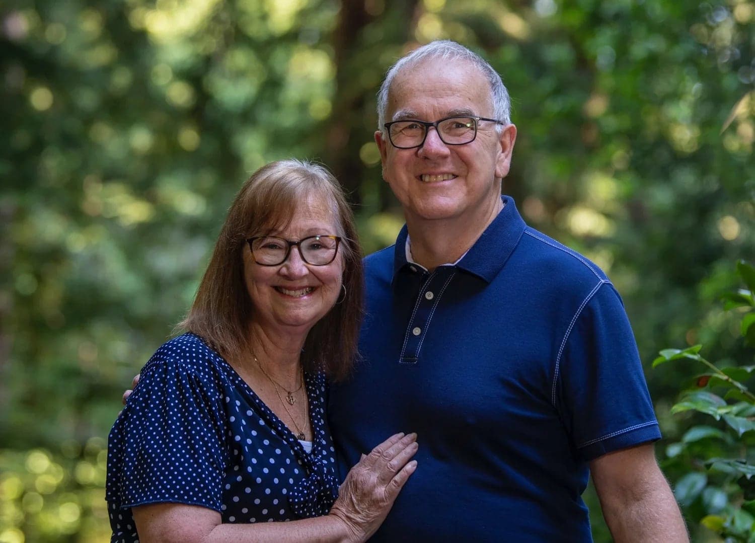 Wes and Judy Wick, founders of YES!, standing together among the redwoods